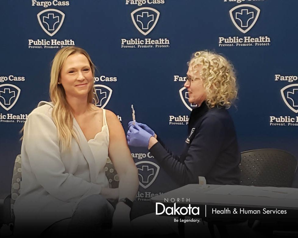 Jessica Schindeldecker, Sanford Health, being immunized by Cheryl Wavering, RN, Fargo Cass Public Health